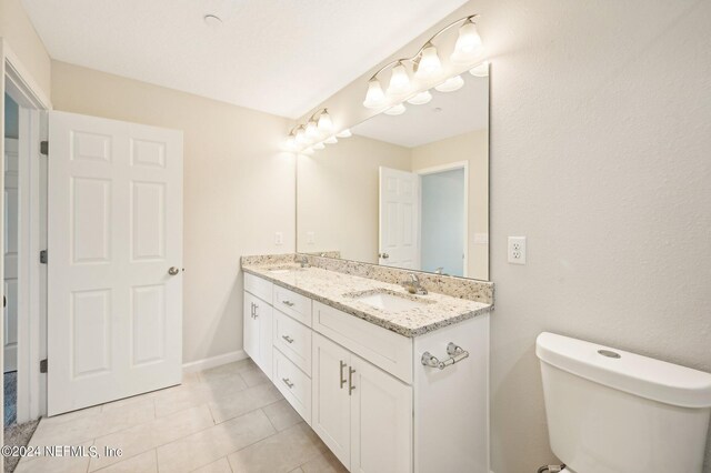 bathroom with tile patterned flooring, vanity, and toilet