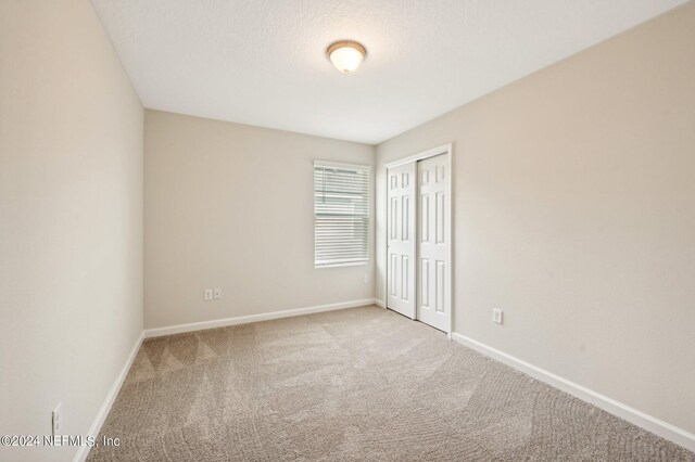 unfurnished room with light colored carpet