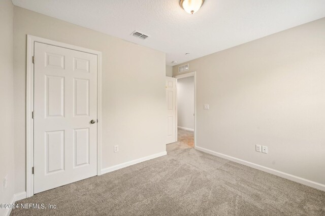 unfurnished bedroom featuring light carpet