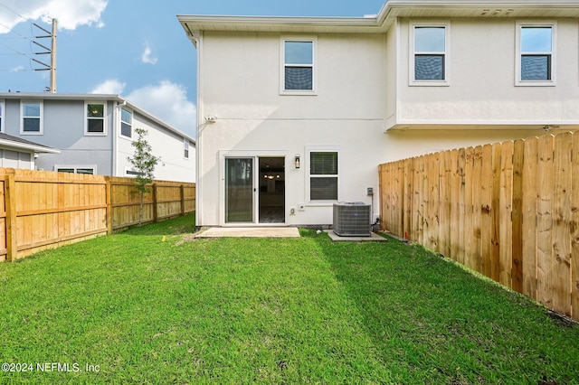 back of property with cooling unit and a lawn