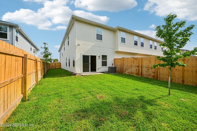 back of house with a lawn and cooling unit