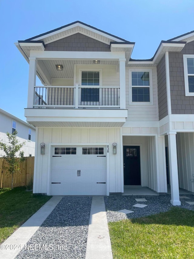 view of front of house with a garage, a balcony, and a front lawn