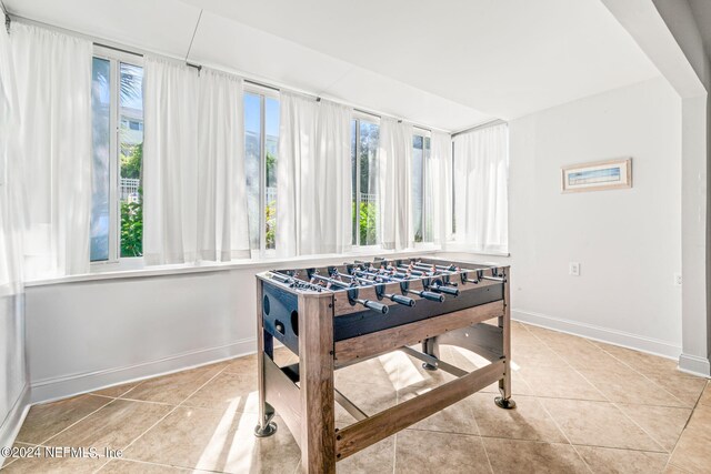 game room with a wealth of natural light and light tile patterned floors