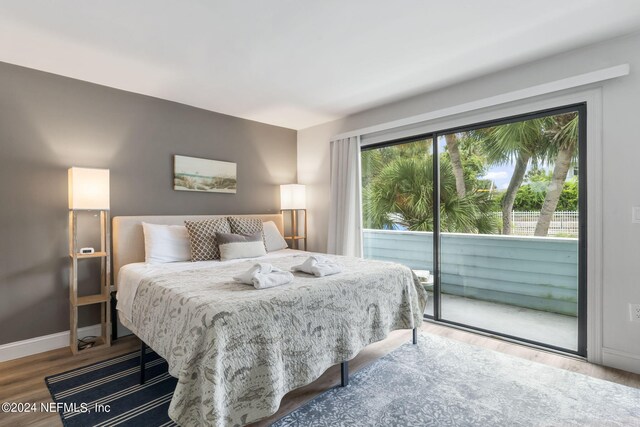 bedroom featuring wood-type flooring and access to outside