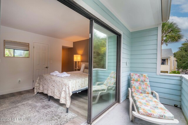 bedroom featuring hardwood / wood-style flooring and wooden walls