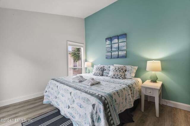 bedroom featuring vaulted ceiling and dark hardwood / wood-style floors