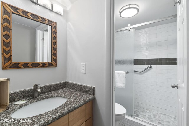 bathroom with vanity, toilet, and a shower with door