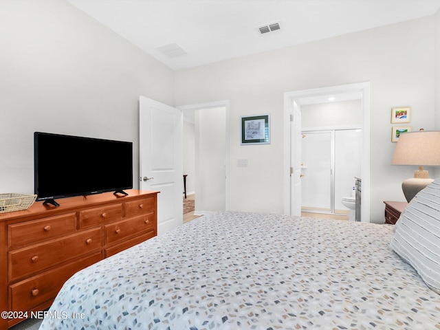 bedroom featuring ensuite bath and visible vents