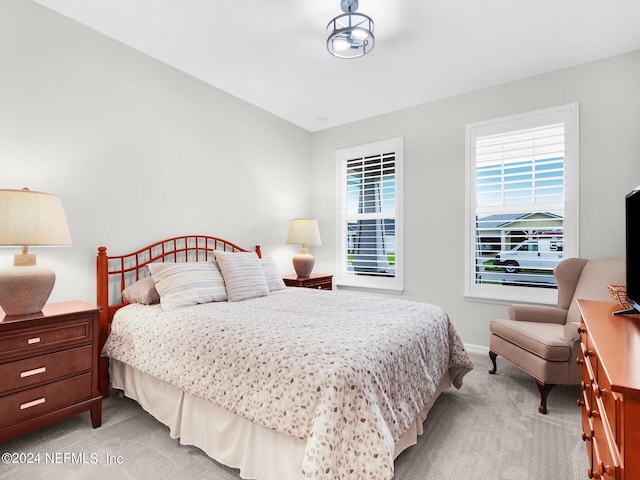 bedroom featuring light carpet and baseboards