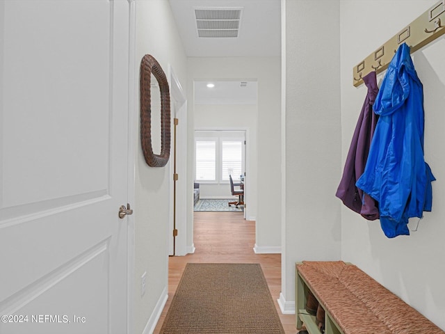 corridor with visible vents, crown molding, baseboards, and wood finished floors