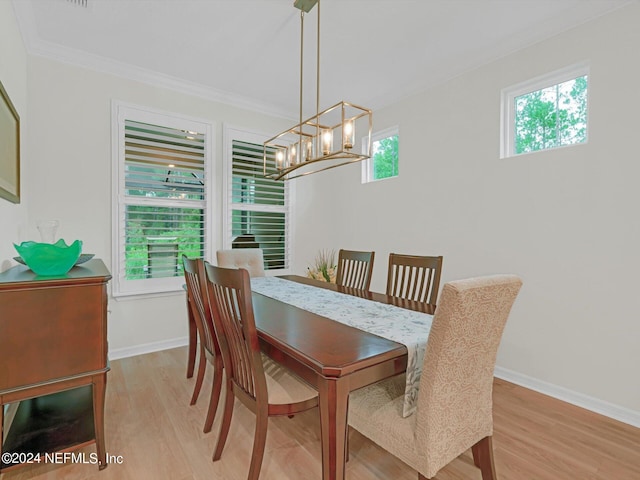 dining room featuring baseboards, crown molding, a notable chandelier, and light wood finished floors