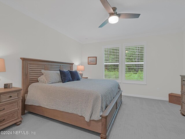 bedroom featuring light carpet, baseboards, a ceiling fan, and ornamental molding