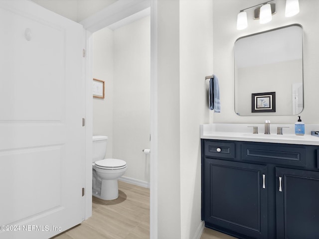 bathroom with vanity, toilet, and baseboards