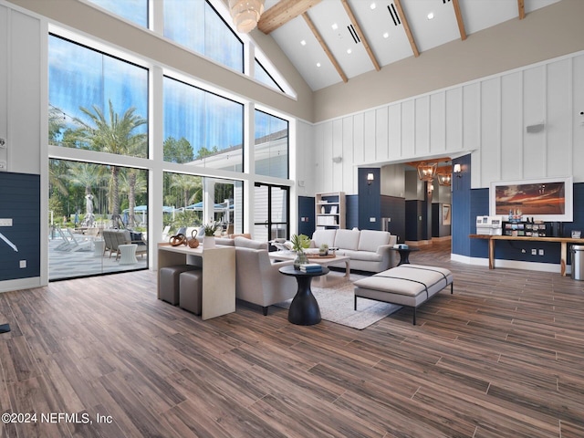 living room featuring a high ceiling, plenty of natural light, wood finished floors, and an inviting chandelier