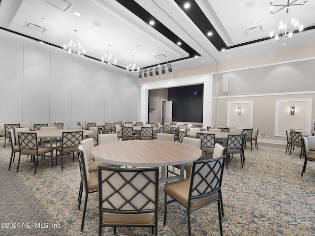 carpeted dining area featuring visible vents, a high ceiling, a chandelier, and a decorative wall