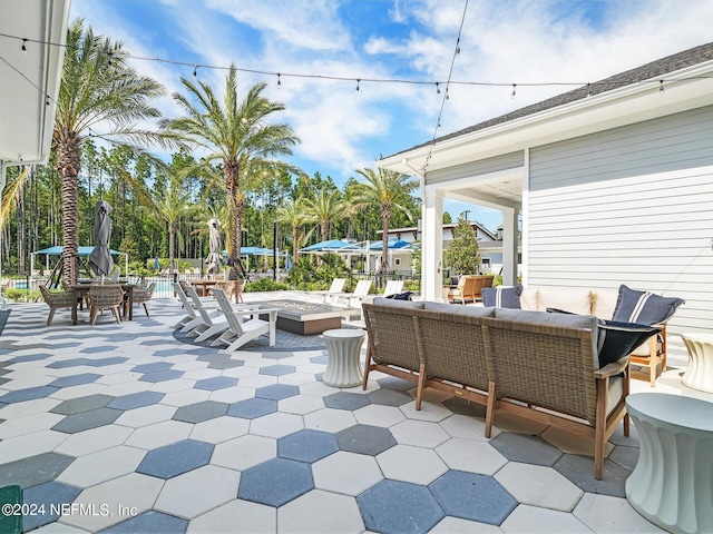 view of patio with an outdoor living space with a fire pit