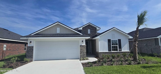 view of front of home with a garage, stone siding, and driveway