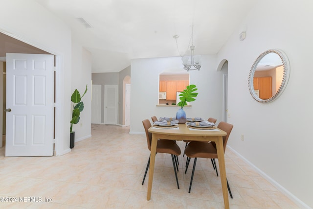 dining room featuring a notable chandelier and light tile patterned flooring