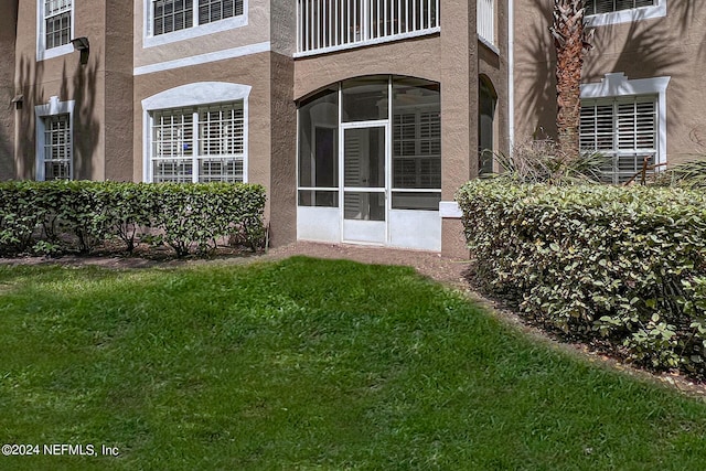 doorway to property featuring a lawn