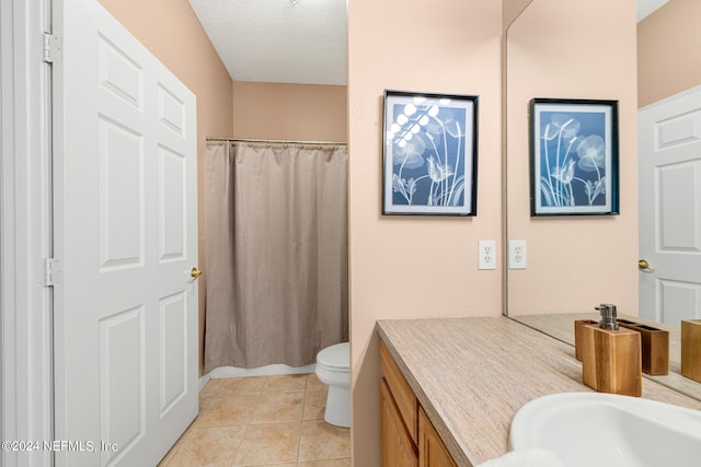 bathroom featuring a textured ceiling, vanity, walk in shower, toilet, and tile patterned floors