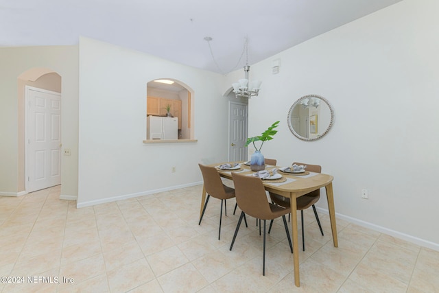 dining room with lofted ceiling, a notable chandelier, and light tile patterned flooring