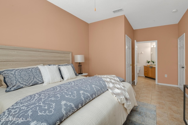 bedroom featuring ensuite bath and light tile patterned flooring