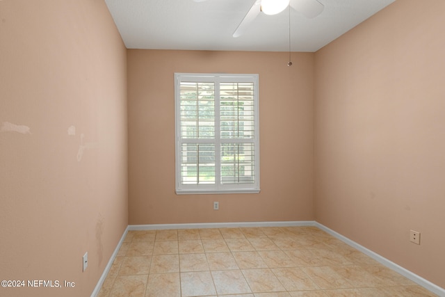 tiled empty room featuring ceiling fan