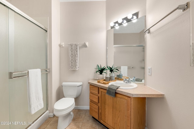 bathroom with tile patterned flooring, toilet, a shower with door, and vanity