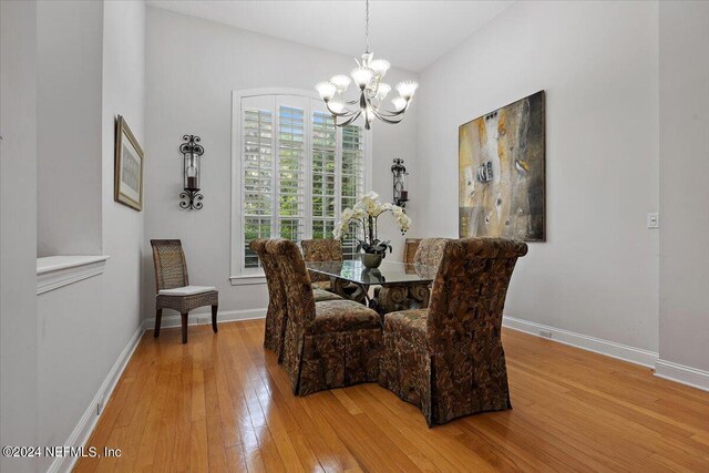 dining space featuring light hardwood / wood-style flooring and a notable chandelier