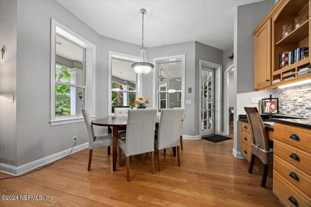 dining space featuring a textured ceiling and light hardwood / wood-style flooring