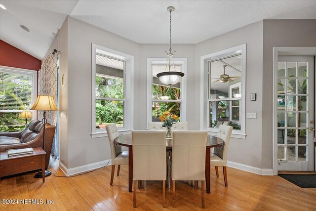 dining area featuring vaulted ceiling, a textured ceiling, ceiling fan, and light hardwood / wood-style floors