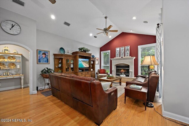 living room with high vaulted ceiling, ceiling fan, and light hardwood / wood-style flooring