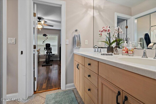 bathroom featuring ceiling fan, hardwood / wood-style flooring, a textured ceiling, and vanity