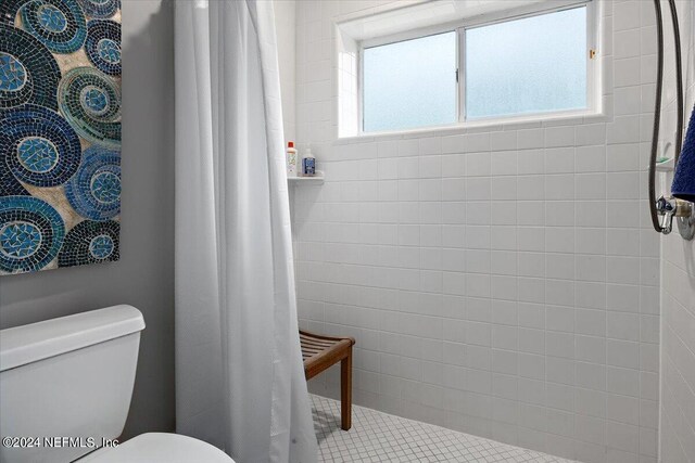 bathroom featuring curtained shower, toilet, and plenty of natural light