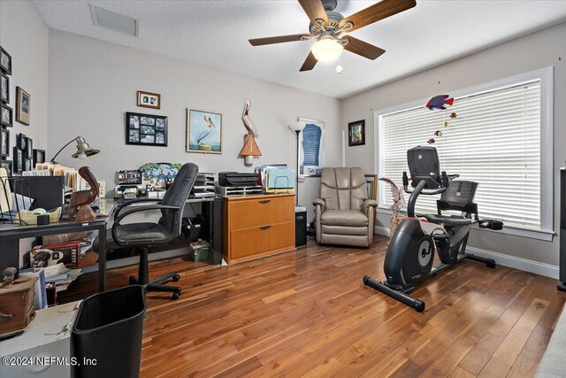 interior space with a textured ceiling, hardwood / wood-style flooring, ceiling fan, and a wealth of natural light