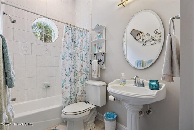 bathroom with tile patterned flooring, toilet, and shower / tub combo with curtain