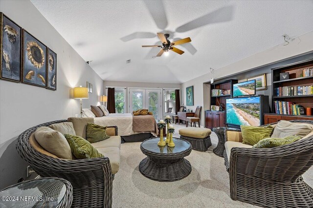 living area featuring a textured ceiling, carpet, ceiling fan, and vaulted ceiling