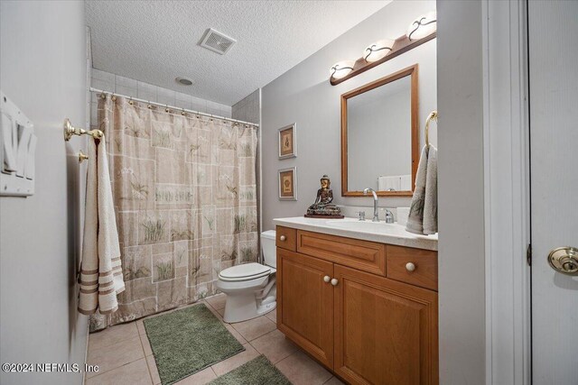 bathroom featuring vanity, toilet, a textured ceiling, and tile patterned flooring