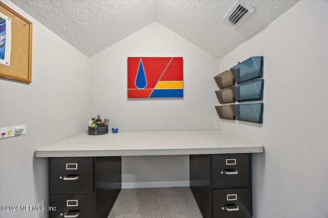 office space with lofted ceiling and a textured ceiling