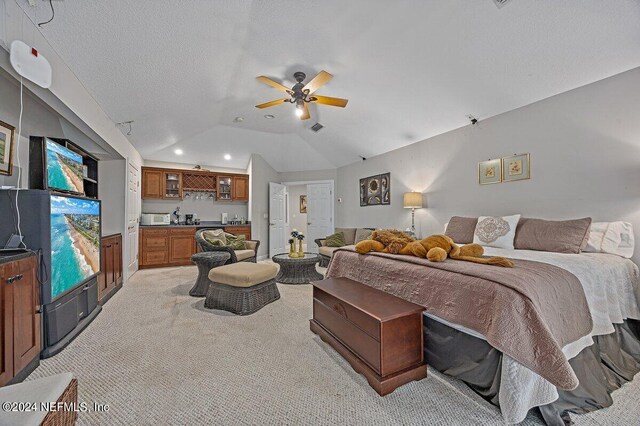 bedroom with lofted ceiling, ceiling fan, light carpet, and a textured ceiling