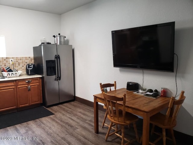 kitchen featuring stainless steel fridge with ice dispenser, tasteful backsplash, and light hardwood / wood-style floors