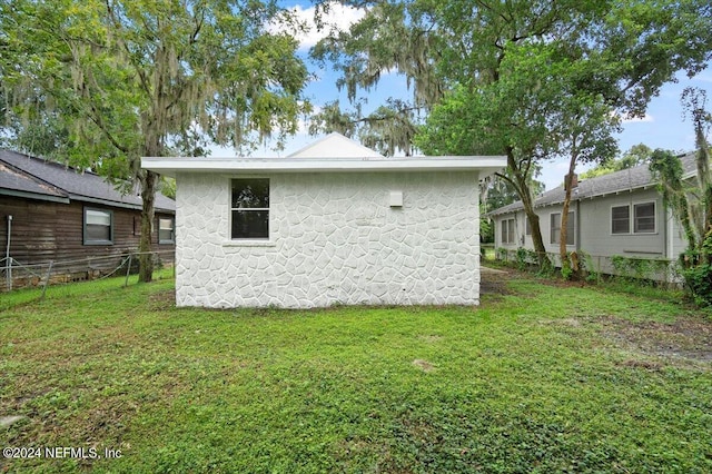 rear view of house featuring a lawn