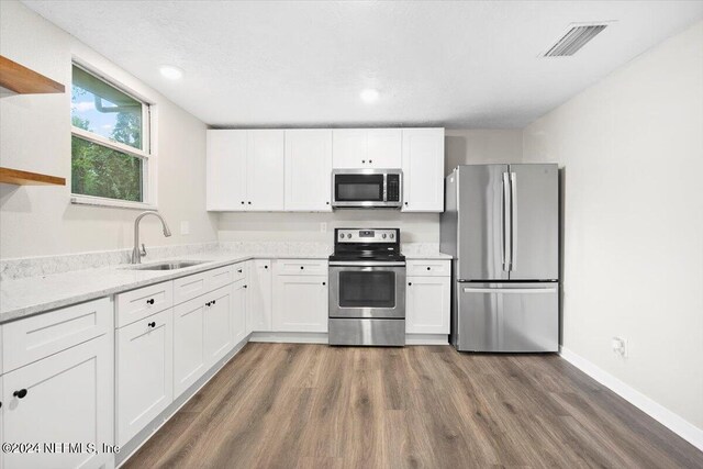 kitchen featuring white cabinets, appliances with stainless steel finishes, dark hardwood / wood-style flooring, and sink