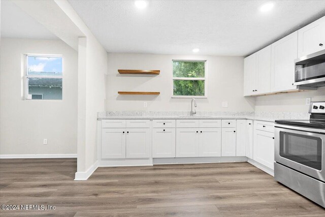 kitchen featuring light hardwood / wood-style flooring, sink, stainless steel appliances, and white cabinets