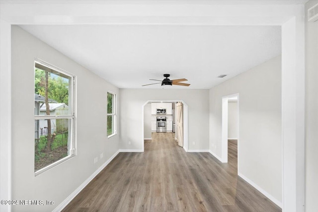 unfurnished living room featuring hardwood / wood-style floors and ceiling fan