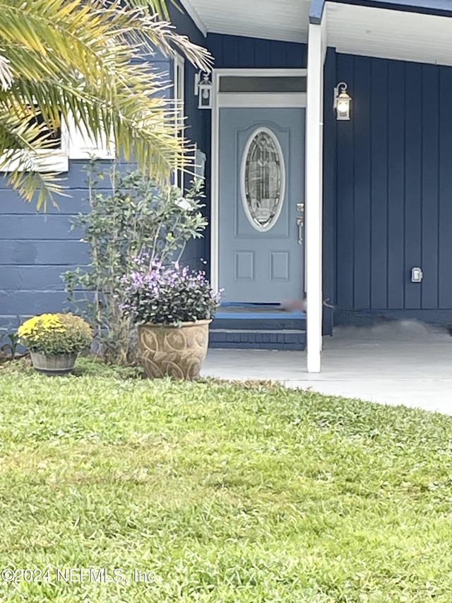 doorway to property featuring a lawn