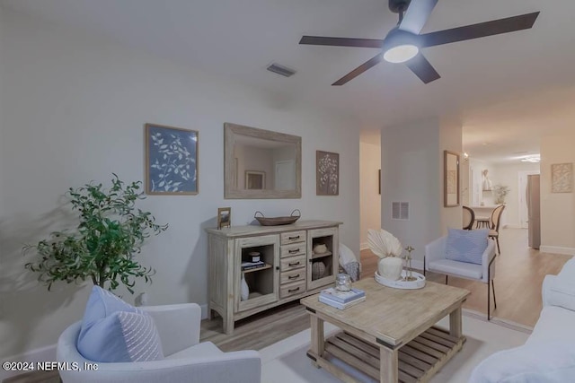 living room featuring ceiling fan and light hardwood / wood-style floors