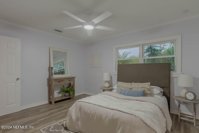 bedroom with hardwood / wood-style flooring, ceiling fan, and crown molding