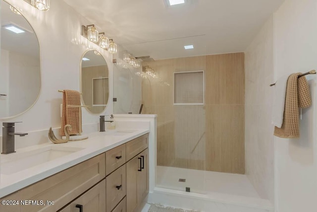 bathroom featuring tiled shower and vanity