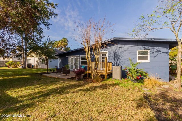 rear view of property with a yard and a patio area